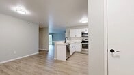 Located at 100 Corrina Blvd in Waukesha, WI, this well-appointed 2-bedroom, 2-bathroom residence offers a thoughtfully designed single-floor layout. The open-concept kitchen and living area serves as the heart of the home, where the kitchen stands out with crisp white shaker cabinetry, stainless steel appliances including a range, microwave, and refrigerator, and a peninsula with a sink — ideal for both cooking and casual dining. Light wood-tone flooring flows throughout the main living areas, lending a clean, modern aesthetic. The spacious living room features a sliding glass door that opens to a private balcony, filling the space with natural light and providing outdoor access. Both bedrooms are generously sized, finished with plush carpeting and ceiling fans, and each benefits from natural light through well-placed windows. The primary bedroom includes a dedicated walk-in closet with built-in wire shelving systems, offering excellent storage. A second walk-in closet provides additional organization space. The bathrooms are finished in a clean, neutral palette with light wood-tone flooring and classic white fixtures. Baseboard heating is present throughout, ensuring year-round comfort in this move-in-ready Waukesha residence.