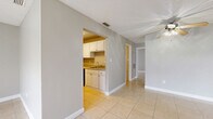 Located at 305 Glades Cir in Largo, Florida, this single-floor, two-bedroom, one-bathroom home offers a practical and functional layout across a compact, efficiently designed footprint. The interior features light beige tile flooring throughout, neutral gray walls, and white baseboards that lend a clean, cohesive look to every room.

The living and dining areas are open and airy, benefiting from large windows and sliding glass door access to an outdoor space, dressed with vertical blinds. A ceiling fan adds comfort to the living area, which also features a textured ceiling.

The galley-style kitchen is well-appointed with white upper and lower cabinetry, a stainless steel sink, a dishwasher, a range, and a full-size refrigerator, all set over the same tile flooring that runs throughout the home.

Both bedrooms are generously sized relative to the overall floor plan, each featuring expansive louvered bi-fold closet doors providing ample storage. The primary bedroom includes multiple closet panels spanning nearly an entire wall. Natural light fills the bedrooms through windows with blinds.

The bathroom is clean and straightforward, featuring a white tiled tub-shower combination. This home offers a bright, low-maintenance living environment well-suited to the Florida lifestyle.