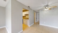 Located at 305 Glades Cir in Largo, Florida, this single-floor, two-bedroom, one-bathroom home offers a practical and functional layout across a compact, efficiently designed footprint. The interior features light beige tile flooring throughout, neutral gray walls, and white baseboards that lend a clean, cohesive look to every room.

The living and dining areas are open and airy, benefiting from large windows and sliding glass door access to an outdoor space, dressed with vertical blinds. A ceiling fan adds comfort to the living area, which also features a textured ceiling.

The galley-style kitchen is well-appointed with white upper and lower cabinetry, a stainless steel sink, a dishwasher, a range, and a full-size refrigerator, all set over the same tile flooring that runs throughout the home.

Both bedrooms are generously sized relative to the overall floor plan, each featuring expansive louvered bi-fold closet doors providing ample storage. The primary bedroom includes multiple closet panels spanning nearly an entire wall. Natural light fills the bedrooms through windows with blinds.

The bathroom is clean and straightforward, featuring a white tiled tub-shower combination. This home offers a bright, low-maintenance living environment well-suited to the Florida lifestyle.
