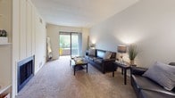 This single-floor, one-bedroom, one-bathroom residence offers a practical and comfortable layout designed for efficient everyday living. The living room provides a welcoming atmosphere, featuring wall-to-wall carpeting, neutral-toned walls, and a sliding glass door that opens to a private balcony with outdoor views of lush greenery, filling the space with natural light. The kitchen and dining area are combined into a functional space finished with tile flooring, dark espresso cabinetry providing ample storage, a full suite of white appliances including a dishwasher and refrigerator, and a dedicated dining area with room for a full table set. The bedroom is a quiet retreat carpeted for comfort, featuring a closet with built-in shelving, a dresser area, and a sliding glass door that extends to a private balcony, offering an airy connection to the outdoors. The full bathroom includes a vanity with a wide countertop, warm wood cabinetry, a large mirror, and a tub-shower combination finished with clean white tile. Throughout the unit, a consistent neutral color palette and practical finishes create a cohesive and move-in ready environment suited for comfortable, everyday living.