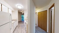 Located at 9455 SW 125th Ave in Beaverton, Oregon, this one-bedroom, one-bathroom unit offers a well-organized single-floor layout with a comfortable and functional design. The living room serves as the heart of the space, highlighted by a tile-surround fireplace with a classic white mantel and tiled hearth, adding a warm focal point to the room. Built-in shelving flanks the wall near a sliding glass door, providing both storage and access to outdoor views. Soft carpet flooring and neutral-toned walls create a clean, understated atmosphere throughout the living and bedroom areas. The bedroom is generously proportioned, featuring large windows that draw in natural light and offer pleasant views of the surrounding greenery and neighborhood. The kitchen is efficiently arranged with white cabinetry and standard appliances, positioned centrally within the unit for convenient access. The bathroom includes a full tub-shower combination with clean white fixtures and wood-look flooring, maintaining a simple and practical aesthetic. Natural light flows throughout the unit via multiple windows, enhancing the overall sense of brightness. This well-maintained unit offers a straightforward, livable layout suited for comfortable everyday living in a residential Beaverton neighborhood.