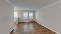 Located at 1100 Pulaski St in Columbia, SC, this well-appointed 2-bedroom, 2-bathroom single-floor residence offers a comfortable and functional layout with modern finishes throughout. The open-concept kitchen and living area serves as the heart of the home, featuring granite countertops, white shaker cabinetry, a subway tile backsplash, and a full suite of stainless steel appliances including a range, microwave, refrigerator, and dishwasher. A peninsula with pendant lighting connects the kitchen to the living area, which is finished with warm hardwood-style flooring, crown molding, and multiple windows that invite natural light. The primary bedroom offers a generous footprint with soft carpeting, a ceiling fan, and windows with outdoor views. The second bedroom, also carpeted, features natural light through multiple windows. Both bathrooms are finished with granite-topped vanities, white cabinetry, and tub-shower combinations with clean tile surrounds and brushed nickel fixtures. Hardwood-style flooring carries through the bathrooms for a cohesive aesthetic. A dedicated laundry area with overhead shelving and washer hookup adds everyday convenience. Neutral tones and textured ceilings carry throughout, creating a clean, move-in-ready environment.