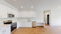 Located at 2385 Sprague Ln in Woodburn, Oregon, this single-floor, 3-bedroom, 2-bathroom home offers a clean, modern design throughout. The open-concept layout seamlessly connects the living room, dining area, and kitchen into one bright, welcoming space. The kitchen is outfitted with crisp white cabinetry extending to the ceiling, white quartz countertops, stainless steel appliances including a range, dishwasher, and built-in microwave, and warm light wood flooring that flows throughout the common areas. A convenient peninsula provides additional prep and casual dining space.

The three bedrooms offer a comfortable retreat, with the primary bedroom featuring its own well-appointed bathroom with a wide vanity, white quartz counters, and ample cabinetry. The additional full bathroom includes a tub/shower combination. Bedrooms are carpeted and receive natural light through windows with outdoor greenery views. Multiple closets provide generous storage throughout.

A private balcony with a glazed railing offers a pleasant outdoor extension of the living space. The home also includes a dedicated laundry area. The neutral color palette, recessed lighting, and consistent finishes give the entire residence a fresh, contemporary feel.