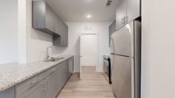 Located at 8402 IBM Drive in Charlotte, NC, this single-story, 2-bedroom, 2-bathroom residence offers a well-designed layout with contemporary finishes throughout. The galley-style kitchen is a functional highlight, featuring gray shaker cabinets, granite countertops, a stainless steel undermount sink, and a full suite of stainless steel appliances including a refrigerator, range, and dishwasher. Light wood-style luxury vinyl flooring runs through the kitchen and living areas, contributing to a clean, cohesive aesthetic.

The living area includes a door with a sidelight window providing natural light and outdoor access. Both bedrooms are carpeted and equipped with ceiling fans. The spacious primary bedroom features multiple windows along two walls, allowing for generous natural light. The second bedroom is comparably sized with its own window. A walk-in closet with built-in wire shelving provides practical storage.

The two bathrooms mirror each other in finish quality, each featuring gray shaker vanities with granite countertops and light wood-style flooring. One bathroom includes a tub-shower combination, while the other offers a walk-in glass-door shower. The overall design is modern, neutral, and move-in ready.