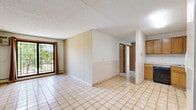 Located at 1701 Elm St SE in Minneapolis, MN, this two-bedroom, one-bathroom unit offers a practical and well-organized single-floor layout. Light-colored ceramic tile flooring runs consistently throughout the space, creating a cohesive and easy-to-maintain interior. The open living and dining area is bright and airy, benefiting from a large sliding window and access to a private balcony that overlooks a landscaped green space with mature trees — a pleasant outdoor retreat. A baseboard heating system is integrated throughout.

The kitchen is efficiently designed with warm wood cabinetry, ample upper and lower storage, a full suite of white appliances including a refrigerator, electric range, and dishwasher, all set beneath a textured ceiling with overhead lighting.

The primary bedroom is a comfortable, well-proportioned room featuring a ceiling fan and a sliding wood-panel closet. The second bedroom is similarly sized, offering flexibility as a guest room or home office, with an adjacent walk-in closet featuring wire shelving for organized storage.

The bathroom includes a double-sink vanity with a marble-style countertop, a walk-in tiled shower with blue accent detailing, and classic black-and-white mosaic tile flooring. The textured ceilings are consistent throughout, adding a traditional character to the space.