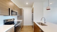 Located at 214 Avondale St in Houston's vibrant Montrose neighborhood, this thoughtfully designed one-bedroom, one-bathroom unit offers a clean, modern aesthetic throughout its efficiently laid-out single floor. Warm-toned luxury vinyl plank flooring runs continuously through every room, creating a cohesive and inviting atmosphere.

The galley-style kitchen is a standout feature, outfitted with stainless steel appliances including an electric range, over-the-range microwave, and a French door refrigerator. Flat-panel, wood-grain cabinetry in a warm walnut tone pairs cleanly with bright white quartz countertops and a stainless steel undermount sink, delivering a sleek, contemporary look.

The combined kitchen and living area flows naturally into a well-proportioned open living space. The bedroom is generously sized, filled with natural light from a large window with views of surrounding greenery, and benefits from a dedicated walk-in closet featuring wrap-around shelving and double hanging rods for ample storage.

The bathroom continues the modern design language, showcasing a floating wood-grain vanity with a white quartz countertop and a large mirror, complemented by a glass-enclosed marble-tiled shower. Recessed lighting and wood-look flooring complete the refined finish. The overall design balances practicality with contemporary style in a prime Houston location.
