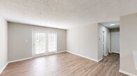 Located at 2002 Cedar Fork Dr in Greensboro, NC, this single-story, 2-bedroom, 2-bathroom residence offers a well-organized layout with a clean, modern aesthetic. Light wood-style flooring runs throughout the home, complemented by neutral warm-gray walls, crisp white trim, and textured ceilings that add subtle character to each room.

The open-concept living, dining, and kitchen area forms the heart of the home. The living room is bright and airy, featuring French doors that invite natural light and provide outdoor access. The kitchen is well-appointed with white cabinetry, a peninsula countertop, stainless steel appliances including a refrigerator and range, and a sink with ample counter space — ideal for everyday cooking and entertaining.

Both bedrooms are comfortably sized, with the primary bedroom offering a ceiling fan, a window with natural light, and direct access to a private bathroom. The bathrooms each feature a tub-shower combination, white vanity cabinetry, and wood-style flooring. Three closets provide generous storage throughout. A dedicated laundry area and a connecting hallway complete the functional floor plan, making this a practical and inviting home.
