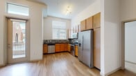 Located at 1596 Stuart St in Denver, Colorado, this single-floor residence offers a well-designed layout with contemporary finishes throughout. The kitchen is a standout feature, boasting warm-toned wood cabinetry, dark granite countertops, and a mosaic tile backsplash that adds visual texture. A full suite of stainless steel appliances — including a refrigerator with ice maker, electric range, built-in microwave, and dishwasher — makes this kitchen both functional and stylish. Light wood-style flooring runs through the kitchen, complementing the bright, neutral walls and enhancing the open feel of the space. Natural light filters in through a window fitted with blinds, keeping the kitchen airy and inviting. The bedrooms feature plush carpeting and notably tall ceilings that amplify the sense of space. One bedroom includes a walk-in closet with built-in shelving, while another benefits from a trio of tall windows that flood the room with natural light and offer views of the surrounding neighborhood. The bathroom is clean and functional, featuring a tiled tub-and-shower combination, a wood-cabinet vanity with dark countertop, and hardwood-style flooring. The overall ambiance of this residence is modern and move-in ready, with thoughtful details throughout.