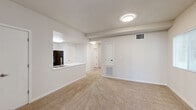 Located at 4401 Truxel Rd in Sacramento, California, this two-bedroom, one-bathroom unit offers a practical and well-organized single-floor layout. The open-concept living, dining, and kitchen area forms the heart of the unit, creating a cohesive and functional shared space. The kitchen features light wood cabinetry, a black refrigerator and electric range, a double-basin sink, and a peninsula with a white countertop that serves as both a workspace and a natural divider between the kitchen and living area. Flooring transitions from wood-look planks in the kitchen to neutral wall-to-wall carpeting in the living and bedroom areas. The primary bedroom receives natural light through a sliding glass door that opens to an exterior balcony, complemented by vertical blinds for privacy. The second bedroom includes a window with blinds, providing a bright and comfortable space. The full bathroom features a wood-toned vanity with a white countertop, a wall mirror, and wood-look plank flooring. Three closets offer generous storage throughout the unit. An in-unit laundry area and a dedicated entrance add convenience. The overall palette of neutral whites and warm beiges gives the space a clean, move-in-ready feel.