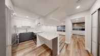 Located in the heart of Montréal's vibrant neighbourhood, this fully renovated 1-bedroom, 1-bathroom unit at 2121 Rue St-Mathieu offers a clean, modern aesthetic with high-quality finishes throughout. Light wood-tone flooring flows consistently across all areas, creating a warm yet contemporary atmosphere. The open-concept kitchen is a standout feature, boasting two-tone cabinetry — crisp white upper cabinets paired with charcoal lower cabinets — complemented by marble-look quartz countertops, a matching backsplash, stainless steel appliances, and a built-in cooktop with a sleek range hood. A peninsula island provides additional workspace and casual seating. A split-level layout adds architectural interest, with a few steps connecting the kitchen and living areas. The spacious living area is bathed in natural light from large floor-to-ceiling windows. The bedroom is generously sized, featuring recessed lighting, clean white walls, and a walk-in closet. The bathroom is elegantly finished with marble-effect wall tiles, a floating grey vanity with quartz countertop, an undermount sink, and a large mirror. In-unit washer and dryer are also included. Recessed lighting throughout enhances the clean, polished ambiance of this thoughtfully designed space.