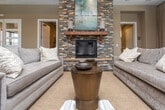 Located at 700 SR-96 E in Bonaire, Georgia, this single-floor space is designed with a refined, welcoming aesthetic that blends warmth and sophistication throughout. The centerpiece of the main lounge area is a striking floor-to-ceiling stacked-stone fireplace, topped with a rich wood mantel and a large framed artwork, creating a commanding focal point. Surrounding seating — including plush sofas and patterned accent chairs — is arranged to encourage relaxed gathering and conversation.

Overhead, an impressive coffered ceiling with dark wood beams and recessed lighting adds architectural depth and a sense of grandeur to the space. Tall, multi-pane glass doors along the exterior wall flood the interior with natural light while offering views of the outdoor surroundings, enhancing the open, airy feel of the room.

Rich hardwood flooring runs throughout, grounding the warm, neutral color palette of the walls and furnishings. A secondary area features a wall-mounted flat-screen television alongside a dark wood display bookcase, offering an additional comfortable retreat. Connecting hallways lead to supplementary rooms, suggesting a well-organized and functional layout. Overall, the space exudes an inviting, upscale ambiance suited for community gathering or hospitality use.