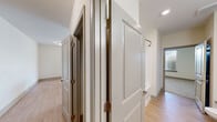 Located at Park Commons Drive in Knightdale, NC, this two-bedroom, one-bathroom residence offers a thoughtfully designed open-concept layout. Light-toned hardwood flooring flows throughout the main living areas, creating a bright and cohesive aesthetic. The kitchen is a standout feature, anchored by a generous island with a granite countertop and undermount sink, complemented by white cabinetry, stainless steel appliances, and stylish pendant lighting. It opens seamlessly into the living area, which is bathed in natural light from large windows with blinds and a ceiling fan overhead. A glass door leads directly to a private balcony, extending the living space outdoors. Both bedrooms are carpeted for comfort and each include ceiling fans. The primary bedroom features a walk-in closet equipped with wire shelving systems for ample storage. The second bedroom offers generous window coverage with outdoor views. The full bathroom includes a granite-topped double vanity with white cabinetry, hardwood-style flooring, and a bathtub. A staircase and in-unit laundry connections round out the functional amenities of this well-appointed Knightdale residence.