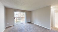 Located at 14095 SW Walker Rd in Beaverton, Oregon, this single-floor unit offers a practical and comfortable layout with a neutral color palette throughout. The living area is generously sized, featuring plush carpeting, textured ceilings, and warm beige walls that create a welcoming atmosphere. A sliding glass door floods the room with natural light and opens directly onto a wood-railed deck, providing pleasant outdoor views of the surrounding greenery. A wall-mounted thermostat and a structural column add functional and architectural character to the space. The open layout connects the living area to the kitchen, which is equipped with white cabinetry, laminate countertops, a stainless steel sink, and white appliances including a range. Ample upper and lower cabinet storage makes the kitchen both efficient and practical. A hallway leads to the additional rooms, including a full bathroom appointed with a shower-tub combination, chrome fixtures, and clean white finishes. The overall design is straightforward and functional, with consistent finishes and neutral tones carried throughout, making the space move-in ready and easy to personalize.