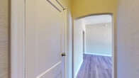 Located at 520 S Mariposa Ave in the Koreatown neighborhood of Los Angeles, this single-floor unit blends classic architectural charm with modern updates throughout. The interior is connected by graceful arched hallways finished with textured walls, lending a distinctive character to the flow between spaces. Durable luxury vinyl plank flooring runs throughout, providing a cohesive and contemporary look underfoot.

The main living area is a standout, featuring an eye-catching exposed brick accent wall surrounding large windows that frame natural light and street views. A ceiling fan overhead and textured plaster walls add to the room's inviting ambiance. An adjacent bedroom offers generous proportions, an open closet alcove, and its own ceiling fan, creating a comfortable and functional retreat.

The kitchen is outfitted with crisp white shaker-style cabinetry, light countertops, a stainless steel sink, and a full-size refrigerator, offering a clean and practical cooking space. The bathroom features a soaking tub, a white vanity with storage, and a window that allows natural light to filter in. A dedicated dressing area with mirrored wardrobe doors and built-in drawer storage adds a thoughtful touch of convenience to the unit's overall layout.