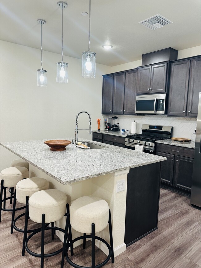 Spacious kitchen with gas range and stainless steel appliances - 6153 N Ceylon St