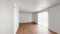 Located on Fairbanks Drive in El Paso, Texas, this two-story, 1-bedroom, 2-bathroom home offers a practical and well-organized layout spread across two floors. The main level features an open living room and kitchen area with warm wood-look flooring throughout. The living room is bright and airy, with a sliding glass door dressed in vertical blinds that invites natural light and provides access to the outdoors. A staircase with a classic railing connects the two levels seamlessly. The kitchen is equipped with rich dark wood cabinetry, light marble-style countertops, a double sink, electric range, and a dishwasher — offering ample storage and prep space. A conveniently placed half bath with a white vanity, dark countertop, and wood-look flooring is also accessible on this floor. Upstairs, the spacious primary bedroom is carpeted for comfort and includes a ceiling fan, a textured ceiling, and two generous side-by-side closets with bi-fold doors, providing excellent storage. The full bathroom features a tiled shower-tub combo, white vanity with dark countertop, framed mirror, and hardwood-style flooring. Textured ceilings are found throughout, adding a consistent architectural detail to this functional and comfortable home.