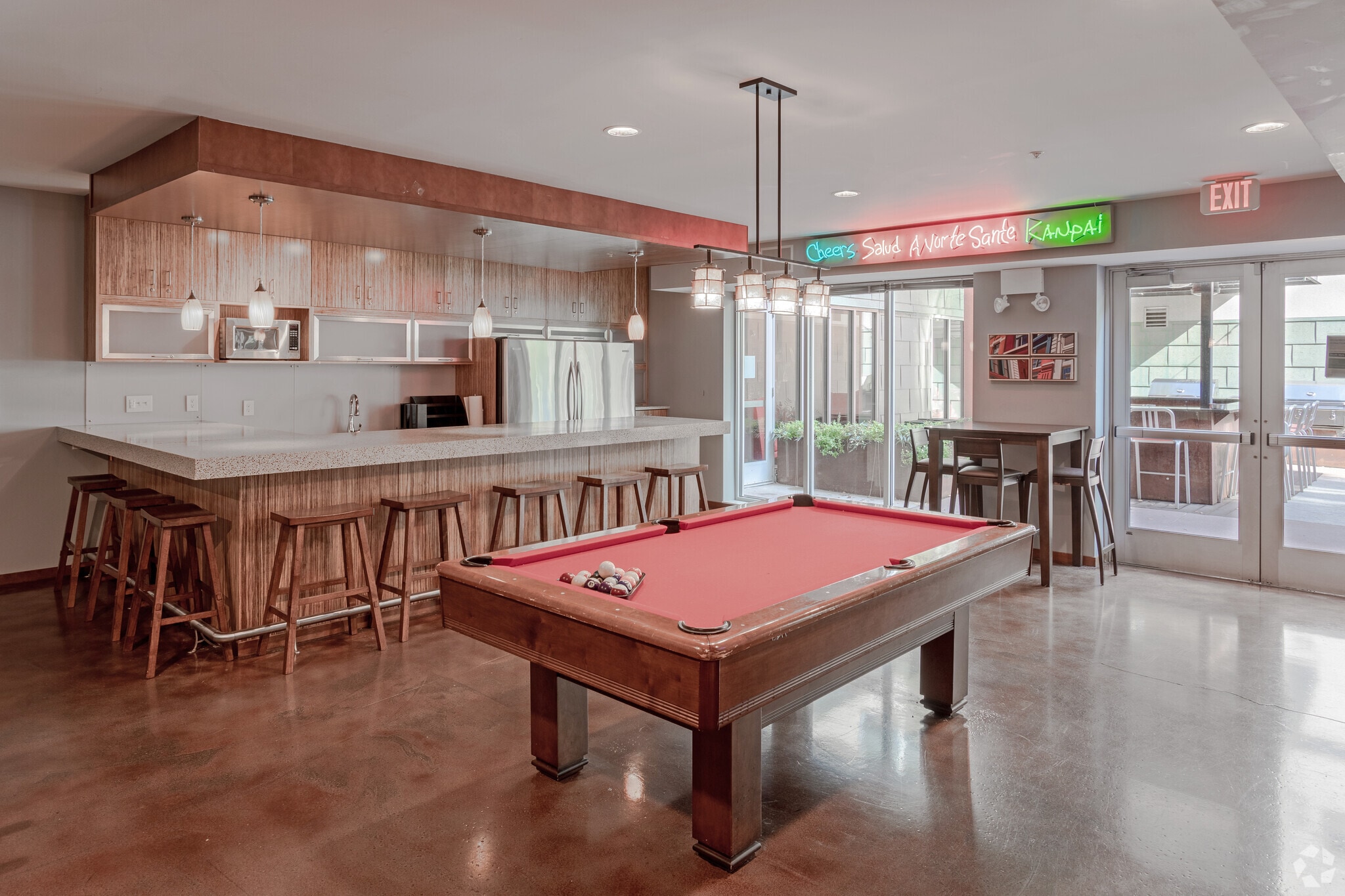 Community room with a pool table, bar, and seating area.