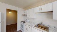 Located at 3069 Ordway Dr NW in Roanoke, Virginia, this single-floor residence offers a clean, well-maintained layout with thoughtfully updated finishes throughout. The living area is spacious and bright, featuring durable wood-style flooring and a large sliding glass door fitted with vertical blinds that invite natural light and provide access to the outdoors. A second open area near the entry also showcases the same wood-style flooring, creating a cohesive flow throughout the main spaces. The kitchen is efficiently designed and features white shaker-style cabinetry, marble-pattern countertops, a white electric range, a stainless steel sink, and a classic white subway tile backsplash, all complemented by an under-cabinet range hood. The bedroom offers plush carpeting, neutral walls, and a window with blinds that allows for natural light while maintaining privacy. The bathroom is neatly appointed with a full soaking tub and shower combination, featuring built-in wall niches for storage and brushed nickel fixtures and grab bar hardware. The overall aesthetic throughout the unit is clean and neutral, with white walls providing a versatile backdrop. A ceiling fan is also present in one of the interior spaces, adding to the comfort of the home.