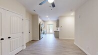 Located at 15 Millswood Dr in Clarksville, Tennessee, this single-story, 3-bedroom, 4-bathroom home offers a well-designed layout with modern finishes throughout. The galley-style kitchen is a standout feature, equipped with stainless steel appliances, shaker-style cabinetry in a two-tone white and gray palette, white quartz countertops, a subway tile backsplash, and light hardwood-style flooring. French doors at the end of the kitchen allow natural light to pour in and provide outdoor access. The three bedrooms are carpeted and each include a ceiling fan and windows that bring in natural light. The primary bedroom offers a comfortable footprint with its own dedicated bathroom. The four bathrooms are finished consistently with light wood-look flooring, white vanities with quartz countertops, gray tile-accented tub-shower combinations, and matte black hardware and fixtures that add a contemporary contrast. One bathroom features a long double-vanity with ample counter space and illuminated mirrors. A dedicated closet provides additional storage. The home's neutral color palette of warm beige walls and white trim creates a clean, cohesive aesthetic throughout every room.