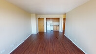 Located at 7022 S South Shore Dr in Chicago's South Shore neighborhood, this single-floor unit offers a practical and well-organized layout. The open living area is anchored by rich, dark hardwood flooring that extends throughout the main living spaces, lending warmth and visual continuity. A large window in the living room admits generous natural light and frames elevated views of the surrounding neighborhood greenery, enhancing the sense of openness.

The kitchen is efficiently designed and positioned adjacent to the living area, featuring warm oak cabinetry — both upper and lower — white tile backsplash, and white appliances including a refrigerator, electric range, and a single-basin sink with ample counter space. The layout makes practical use of the available footprint.

The bedroom is carpeted for comfort and includes a ceiling fan with a light fixture, a built-in closet with sliding doors, and good natural light. It offers a calm, functional retreat.

The bathroom is finished in classic white tile, featuring a pedestal sink, a mirrored medicine cabinet with an illuminated bar, and a full-size bathtub with a shower. The clean, bright aesthetic gives the space a timeless feel. Overall, the unit presents a functional and well-maintained living environment in a recognizable Chicago high-rise setting.