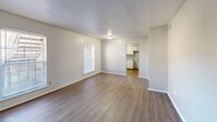 Located at 4118 Auburn Road in Memphis, TN, this single-story, 2-bedroom, 1-bathroom home offers a practical and comfortable layout. Wood-look laminate flooring runs consistently throughout the entire home, providing a cohesive and easy-to-maintain interior. The living room is a welcoming space highlighted by a large window that invites natural light and offers views of the surrounding outdoors. It connects directly to the kitchen, creating an open and accessible flow. The kitchen features white cabinetry, white appliances including an electric range and refrigerator, a built-in shelving nook, and a sink with ample counter space — all set beneath a textured ceiling. Both bedrooms are well-proportioned with neutral gray walls, textured ceilings, and windows providing natural light. The primary bedroom includes a closet, while the second bedroom also features a closet with access to a hallway connecting to the main areas. The shared bathroom showcases white tile walls and a vanity with light countertops. A central hallway links the bedrooms and bathroom efficiently. Throughout the home, consistent neutral tones, clean white trim, and an understated design palette create a simple and functional living environment.