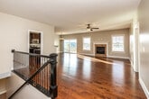 This two-floor home is thoughtfully designed to balance open, communal spaces with private retreats. The main level centers around a generously proportioned living room finished with rich hardwood flooring that reflects abundant natural light streaming through multiple windows and a sliding glass door leading to an outdoor deck. A tile-surround fireplace with a classic white mantel serves as the room's focal point, complemented by a ceiling fan and a chandelier in the adjacent dining area. The kitchen features dark espresso cabinetry extending to the ceiling, granite countertops, and a full suite of stainless steel appliances, including a gas range, built-in microwave, and refrigerator.

The upper level offers carpeted bedrooms, including a spacious primary suite with a tray ceiling, ceiling fan, and generous natural light. The primary bathroom is well-appointed with large-format tile flooring, a soaking tub set within a tile surround, a separate glass-enclosed shower with stone tile walls, and granite-topped vanity. Secondary bedrooms include closets and share a full bathroom with a tub-shower combination and granite countertops. The unfinished basement presents significant potential for additional living or storage space.