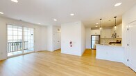 Located at 50 Kirby Ave in Somerville, NJ, this two-story, 2-bedroom, 2-bathroom home offers a thoughtfully designed layout across two floors. The main living level features an open-concept kitchen and living area bathed in natural light, with light-toned hardwood flooring throughout. The modern kitchen is outfitted with white shaker cabinets, a subway tile backsplash, stainless steel appliances, a peninsula with an undermount sink, and pendant lighting — combining both style and functionality. Sliding glass doors lead from the living area to a private balcony, enhancing the sense of openness. Carpeted stairs connect the levels, leading to two well-sized bedrooms, each with hardwood floors and ample natural light from large windows. The primary bedroom is generously proportioned with closet access and connects to the hallway. Both bathrooms feature floating navy-blue vanities with white countertops, modern black fixtures, and clean, contemporary finishes. A hallway ties the upper level together seamlessly. The ground floor includes an attached garage with direct interior access via a private entrance. Clean white walls, recessed lighting, and consistent finishes throughout give this home a bright, cohesive, and move-in-ready aesthetic.