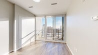 Located at 140 Main St W in the heart of Hamilton, Ontario, this one-bedroom, one-bathroom unit offers a thoughtfully designed layout that maximizes every square foot of its compact footprint. The interior features light-toned hardwood-style flooring throughout, crisp white trim, and a neutral colour palette that creates a clean, modern aesthetic.

The open-concept living and kitchen area flows seamlessly, with the kitchen outfitted with white cabinetry, a tiled backsplash, and a stainless steel dishwasher. The living area receives generous natural light and connects directly to a private balcony via floor-to-ceiling sliding glass doors, offering impressive elevated views of the Hamilton skyline.

The bedroom is a comfortable size, featuring large floor-to-ceiling windows that frame sweeping city views and fill the room with natural light. A dedicated closet provides practical storage space.

The bathroom is finished with a stone-topped vanity, an undermount sink, a soaker tub with tiled surround, and chrome fixtures, maintaining the unit's clean, contemporary feel. In-suite laundry adds convenience, while a well-proportioned entry corridor with overhead lighting provides a polished arrival experience. This unit is ideal for those seeking modern urban living in downtown Hamilton.
