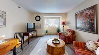 Located at 1555 118th Ln NW in Coon Rapids, Minnesota, this well-appointed one-bedroom, one-bathroom unit offers a functional and comfortable single-floor layout. The open-concept main living area seamlessly connects the kitchen, dining space, and living room, creating an efficient and inviting atmosphere throughout. Light wood-style flooring flows across the shared living areas, complemented by neutral wall tones and textured ceilings.

The kitchen is well-equipped, featuring warm oak cabinetry with ample upper and lower storage, light countertops, a full suite of appliances including a range, microwave, dishwasher, and refrigerator, and a double sink. A central support column subtly defines the transition between the kitchen and the living area. The living room benefits from a large window that brings in natural light and offers views of the surrounding landscape, creating a bright and welcoming retreat.

The bedroom offers a comfortable, carpeted space with a window for natural light and direct access to a closet. The unit also includes a total of four closets, providing generous storage throughout. The bathroom is clean and practical, featuring a vanity with oak cabinetry, a well-lit mirror, and a shower-tub combination. This thoughtfully designed unit delivers efficient, comfortable living in a convenient Coon Rapids location.