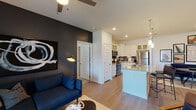 Located at 3761 Raleigh Road Parkway in Wilson, NC, this single-floor residence combines modern design with functional living. The open-concept layout seamlessly connects the living room and kitchen, creating an inviting and cohesive space. The living area features a bold dark accent wall, ceiling fan, and large glass doors that open to a private balcony, allowing natural light to fill the room and offering outdoor views.

The kitchen is equipped with stainless steel appliances, including a refrigerator, electric range, and microwave. White shaker-style cabinetry with glass-front upper panels, granite countertops, a subway tile backsplash, and a central island with pendant lighting complete the space, offering both style and practicality.

The primary bedroom features a deep navy accent ceiling, plush carpet, generous natural light from large windows, and a spacious walk-in closet with wire shelving. A second bedroom offers similar comfort with carpeted flooring and closet access. The bathroom is well-appointed with a granite-topped vanity, glass-enclosed walk-in shower, and clean white finishes. A dedicated in-unit laundry area with a full-size washer and dryer adds everyday convenience to this thoughtfully designed residence.