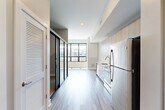 Located at 960 Greene St in Ann Arbor, MI, this efficiently designed one-bedroom, one-bathroom unit offers a thoughtfully planned layout across a single floor. The open-concept living, dining, and kitchen area serves as the heart of the space, bathed in natural light from large, floor-to-ceiling windows with sleek black frames that provide views of the surrounding neighborhood. Light-toned luxury vinyl plank flooring flows throughout the main living area, lending a clean and contemporary aesthetic.

The modern kitchen is well-appointed with flat-front wood-grain cabinetry extending to the ceiling, white quartz countertops, a classic subway tile backsplash, and a full suite of stainless steel appliances including a refrigerator, electric range, built-in microwave, and dishwasher. A sliding glass door adds a stylish division between the entry corridor and the living space.

The bedroom features plush carpeting, neutral gray walls, and a closet, offering a quiet retreat. The bathroom is finished with a frameless glass walk-in shower, wood-tone vanity cabinetry, and clean white surfaces. Additional conveniences include in-unit laundry and two closets, rounding out this functional and modern Ann Arbor residence.