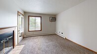 This 2-bedroom, 1-bathroom unit in Sioux Falls, South Dakota offers a practical and well-organized single-floor layout. The combined kitchen and living area forms the heart of the home, with the kitchen featuring warm oak cabinetry, a peninsula breakfast bar, light vinyl flooring, and white appliances including a range, over-the-range microwave, and refrigerator. A ceiling fan overhead adds comfort to the living space. Both bedrooms are carpeted and equipped with ceiling fans and wood-trimmed windows that allow natural light to filter in, with views of surrounding greenery. The primary bedroom is a comfortable size, while the second bedroom provides additional flexibility. Baseboard heating runs throughout the unit, and a wall-mounted air conditioning unit in one bedroom ensures year-round comfort. The full bathroom includes a tub/shower combo and tile flooring. A dedicated in-unit laundry room comes equipped with a full-size washer and dryer and overhead wire shelving for storage. Neutral wall tones and consistent trim work lend a clean, cohesive feel throughout the space. Located in the 57105 zip code area of Sioux Falls, this unit offers convenient, functional living.