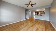 Located at 3385 Cedar Valley Way in Hamburg, NY, this well-designed single-floor home offers 2 bedrooms and 2 bathrooms within a thoughtfully laid-out floor plan. The open-concept kitchen and living room serve as the heart of the home, where light hardwood-style flooring flows seamlessly throughout. The kitchen is appointed with dark espresso cabinetry, stainless steel appliances including a refrigerator, gas range, and microwave, and a peninsula with a white quartz countertop and pendant lighting above — ideal for both cooking and casual dining. The spacious living room features a ceiling fan and sliding glass doors that invite natural light and outdoor access. The generously sized primary bedroom includes a ceiling fan, bright windows, and access to a well-appointed en-suite bathroom featuring a double-sink vanity with dark cabinetry, white countertops, and a glass-enclosed shower. A walk-in closet with built-in wire shelving provides ample storage. The second bedroom is equally bright with a large window and hardwood-style flooring. A second full bathroom serves the remaining rooms. The home also includes a dedicated hallway system connecting all areas efficiently, and an attached garage with an automatic opener, offering convenient covered parking and additional storage.