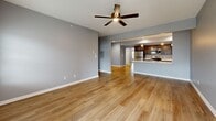 Located at 3385 Cedar Valley Way in Hamburg, NY, this well-designed single-floor home offers 2 bedrooms and 2 bathrooms within a thoughtfully laid-out floor plan. The open-concept kitchen and living room serve as the heart of the home, where light hardwood-style flooring flows seamlessly throughout. The kitchen is appointed with dark espresso cabinetry, stainless steel appliances including a refrigerator, gas range, and microwave, and a peninsula with a white quartz countertop and pendant lighting above — ideal for both cooking and casual dining. The spacious living room features a ceiling fan and sliding glass doors that invite natural light and outdoor access. The generously sized primary bedroom includes a ceiling fan, bright windows, and access to a well-appointed en-suite bathroom featuring a double-sink vanity with dark cabinetry, white countertops, and a glass-enclosed shower. A walk-in closet with built-in wire shelving provides ample storage. The second bedroom is equally bright with a large window and hardwood-style flooring. A second full bathroom serves the remaining rooms. The home also includes a dedicated hallway system connecting all areas efficiently, and an attached garage with an automatic opener, offering convenient covered parking and additional storage.