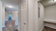 This single-story, 3-bedroom, 2-bathroom home offers a thoughtfully designed layout with a blend of modern finishes and functional living spaces. The open-concept living and dining area is anchored by durable wood-look flooring, a ceiling fan with light fixture, and a large arched window that fills the space with natural light. The dining room features elegant crown molding, a decorative chandelier, chair rail detailing, and direct sight lines into the kitchen through a pass-through opening. The kitchen is well-equipped with white shaker-style cabinetry, granite countertops, a mosaic tile backsplash, black appliances, and a peninsula with an undermount sink. Each of the three bedrooms is carpeted and finished with neutral wall tones and textured ceilings, providing a comfortable and quiet retreat. The primary bedroom includes a walk-in closet outfitted with wire shelving for ample storage. Two full bathrooms serve the home, one featuring a tub-shower combination with brushed nickel fixtures, wood-look flooring, and a granite-topped vanity. Connecting the rooms are two hallways that provide smooth circulation throughout. Additional closets offer generous storage capacity, rounding out this practical and move-in-ready home.