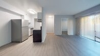 Located at 2404 Tate Springs Rd in Lynchburg, Virginia, this single-floor unit offers a clean, functional layout designed for comfortable everyday living. The open-concept kitchen and living area form the heart of the space, finished with light wood-look flooring that extends throughout the common areas. The kitchen is equipped with stainless steel appliances, including an electric range and refrigerator, complemented by white cabinetry with brushed nickel hardware and gray speckled countertops. A kitchen island provides additional prep space and defines the transition to the living area. The spacious living room features neutral gray walls and generous floor space, allowing for flexible furniture arrangements. Multiple bedrooms are finished with plush carpet and soft blue-gray walls, each offering natural light through blinded windows. The bedrooms provide ample storage through dedicated closets, including walk-in configurations in select rooms. One bedroom features a convenient en-suite bathroom access. The bathroom is finished in white, featuring a full tub-shower combination, a vanity with white cabinetry, and matching light flooring. Throughout the unit, clean lines, neutral tones, and consistent finishes create a cohesive and inviting atmosphere.