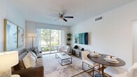 Located at 12171 Treeline Ave in Fort Myers, FL, this single-story 2-bedroom, 1-bathroom residence offers a thoughtfully designed layout with modern finishes throughout. The open-concept living area is bright and welcoming, featuring light wood-look flooring, a ceiling fan, and a sliding glass door that floods the space with natural light and provides access to a private outdoor patio with lush greenery views. The living room comfortably accommodates both a seating area and a dining space, creating a versatile and functional environment.

The kitchen is a standout feature, boasting white shaker cabinetry, granite countertops, a subway tile backsplash, stainless steel appliances, and a kitchen island with bar seating — a perfect space for both cooking and entertaining. The primary bedroom is generously sized, offering plush carpeting, large windows with ample natural light, and a serene, neutral color palette with a charcoal accent wall. The second bedroom is equally well-proportioned and bright.

The bathroom is finished with marble-style wall tile surrounding the soaking tub and shower, complemented by granite vanity countertops, white cabinetry, and wood-look flooring. A dedicated laundry area and hallway closet add practical storage and convenience to this polished home.