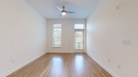 Located at 4520 Charlotte Park Dr in Charlotte, NC, this well-appointed single-floor residence offers a clean, modern aesthetic throughout. The open living area is bright and airy, featuring warm hardwood-style flooring, crisp white walls, and a ceiling fan with integrated lighting. Tall windows and a glass-panel door flood the space with natural light while offering pleasant outdoor views of surrounding greenery.

The kitchen is thoughtfully designed with white shaker-style cabinetry, granite countertops, a classic white subway tile backsplash, and a full suite of stainless steel appliances, including a refrigerator, range, over-the-range microwave, and dishwasher. The kitchen flows naturally into the main living area, creating an open and functional layout ideal for daily living and entertaining.

The bedroom features plush neutral carpeting, ample wall space, and additional windows that continue the unit's emphasis on natural light and outdoor connectivity. A dedicated exterior door in the bedroom provides added convenience and access.

The bathroom is finished with white shaker vanity cabinetry, granite countertops, a large mirror with overhead lighting, and consistent hardwood-style flooring, reflecting the cohesive design language found throughout the entire space.