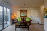 Located at 552 Rico St in Salinas, California, this single-floor residence offers two bedrooms and two full bathrooms within a well-organized and functional layout. The open-plan living and dining area serves as the heart of the home, with soft carpet underfoot and a sliding glass door that fills the space with natural light and provides direct access to a private outdoor patio. The dining area comfortably accommodates a round glass table and is lit by a pendant light fixture, with a window offering views of the surrounding neighborhood. The kitchen features warm wood cabinetry, tile countertops, a tiled floor, and a full suite of appliances including a refrigerator, dishwasher, and range. A window above the sink brings in additional natural light. The primary bedroom is a comfortably sized retreat with soft carpeting and warm ambient lighting. The second bedroom includes a large sliding-door closet and neutral finishes, making it versatile as a guest room or home office. Both bathrooms are identically appointed with tile flooring, wood-toned vanity cabinetry, and a shower-tub combination enclosed by sliding glass doors. A connecting hallway ties all rooms together efficiently, completing this practical and well-appointed Salinas residence.