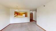 Located at 3533 Willow Ave in White Bear Lake, Minnesota, this one-bedroom, one-bathroom unit offers a well-organized, single-floor layout designed for comfortable everyday living. The open-concept kitchen and dining area serves as the heart of the home, where warm honey-toned wood cabinetry lines the walls of a fully equipped kitchen featuring a range, refrigerator, dishwasher, and a double sink. A pass-through counter with overhead pendant lighting connects the kitchen to the dining area, enhancing the sense of openness. The flooring transitions from durable hardwood-style planks in the kitchen and entry areas to plush carpet in the living and bedroom spaces. The carpeted bedroom offers a peaceful retreat with a large window that invites natural light and outdoor views. A dedicated laundry room provides the convenience of in-unit washer and dryer hookups with overhead shelving. The full bathroom is finished with a wood-toned vanity, a large mirror, hardwood-style flooring, and accessibility-friendly grab bars in the tub and toilet area. Throughout the unit, clean white walls, warm wood trim, and textured ceilings create a consistent and inviting aesthetic.