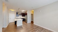 Located in the heart of downtown Indianapolis on E Market Street, this 2-bedroom, 3-bathroom residence offers a thoughtfully designed single-floor layout. The open-concept kitchen and living area serves as the centerpiece of the home, featuring rich dark-espresso cabinetry, stainless steel appliances including a refrigerator, range, microwave, and dishwasher, and a generous island with a light quartz countertop, illuminated by stylish pendant lighting. Wood-look flooring flows throughout the main living areas, adding warmth and continuity. The living space receives natural light through large windows dressed with blinds. Both bedrooms are carpeted and well-sized, with the primary bedroom offering notable square footage and multiple windows. The bathrooms are finished with dark vanity cabinetry, white quartz countertops, large mirrors, and tiled tub-shower combinations featuring an elegant mosaic accent border. Four closets, including walk-in options with wire shelving, provide abundant storage. A dedicated laundry area adds everyday convenience. The neutral color palette and clean, modern aesthetic throughout create a cohesive and functional living environment well-suited to urban life.