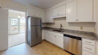 This single-floor residence at 94 Broad Reach in Weymouth, MA offers a well-organized layout with a range of practical and comfortable features throughout. The kitchen is a functional highlight, equipped with white shaker-style cabinetry extending to the ceiling with crown molding detail, granite countertops, a double sink, and a full suite of stainless steel appliances including a refrigerator and dishwasher. Tile flooring completes the clean, polished look of the space.

The living area is generously sized, featuring neutral carpet, warm cream-toned walls, and large windows that frame scenic water views — a notable feature that brings natural light and an open, airy feel to the space. Access to a balcony is also visible from the living area.

The bedrooms are carpeted and well-proportioned, with windows offering additional water and outdoor views, providing a calm and bright atmosphere. Closet space is included.

Two bathrooms serve the unit. One features a tub/shower combination with tile flooring and a white vanity, while the second offers a larger vanity with an illuminated mirror, a tub/shower with a grab bar, and matching tile floors. Both bathrooms maintain a clean, neutral aesthetic throughout.