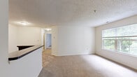 Located at Mallard Landing Circle in Midlothian, Virginia, this two-bedroom, one-bathroom residence offers a practical and comfortable single-floor layout. The open-concept kitchen and living area serves as the heart of the home, with the kitchen featuring warm wood cabinetry, dark countertops, white appliances including a refrigerator and range, and tile flooring that extends into the living space. A peninsula counter provides a natural division between the kitchen and the adjoining living area, creating a functional flow throughout.

Both bedrooms are carpeted and bathed in natural light through windows with outdoor views of surrounding greenery. The spacious primary bedroom includes a louvered closet door and a wall-mounted heating unit, while the second bedroom offers a similarly bright and open feel. Textured ceilings are consistent throughout the living areas and bedrooms, adding a classic residential character.

The full bathroom is finished with tile flooring, a tub/shower combination, and a vanity with dark countertop detailing. A dedicated laundry room with wire shelving overhead, tile flooring, and washer/dryer hookups adds everyday convenience. A separate closet provides additional storage. The neutral color palette and practical finishes throughout make this a move-in ready home in a well-situated Midlothian community.