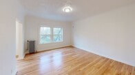 Located at 713 Tacoma Ave S in the heart of Tacoma, Washington, this efficiently designed single-floor unit offers a well-organized layout across its cozy footprint. Polished hardwood floors extend throughout the space, lending warmth and a timeless aesthetic to every room.

The living room serves as the central gathering area, filled with natural light streaming through a double-pane window that frames views of surrounding trees. A classic cast-iron radiator provides character and reliable heat, while a textured ceiling and flush-mount light fixture complete the room's classic charm.

From the living room, the layout opens to a hallway connecting the remaining spaces, including a dedicated closet with ample shelving for storage. The laundry area is thoughtfully appointed with white upper and lower cabinetry, a stainless steel sink, and a rich butcher block countertop—offering both utility and style.

The bathroom features a full tub-shower combination with elegant marble-style surround panels, brushed nickel fixtures, and a clean pedestal sink beneath a well-lit vanity mirror, creating a crisp and functional space. Throughout the unit, bright white walls and consistent hardwood flooring unify the interior with a clean, cohesive look. This unit is ideal for those seeking a manageable, move-in-ready space in a walkable Tacoma neighborhood.