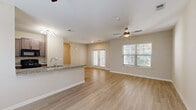 Located at 3340 Shipley St in North Charleston, SC, this single-story, 2-bedroom, 2-bathroom home offers a thoughtfully designed open-concept layout with clean, modern finishes throughout. The combined kitchen and living area serves as the heart of the home, featuring light wood-tone flooring, neutral walls, and a ceiling fan that enhances airflow and comfort. The kitchen is equipped with dark wood cabinetry, black appliances, track lighting, and a granite-topped peninsula with an integrated sink — ideal for casual dining or entertaining. The spacious living room benefits from multiple windows with blinds and French doors that invite natural light and outdoor views. Both bedrooms are carpeted and comfortable, each with a ceiling fan and windows providing natural light. The bedrooms include access to dedicated closets for ample storage. The bathrooms are well-finished, with one featuring a granite vanity, dark wood cabinetry, wood-look tile flooring, and a full tub-shower combination. A second bathroom provides a convenient half-bath layout. A dedicated laundry area houses a full-size washer and dryer with overhead shelving. The hallway connects all rooms efficiently, completing this functional and inviting single-floor layout.