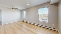Located at 925 Kirkwood Pkwy SW in Cedar Rapids, Iowa, this 2-bedroom, 1-bathroom unit offers a well-organized single-floor layout with a thoughtful mix of finishes and functional design. The open-concept kitchen and living area serves as the heart of the home, featuring warm oak cabinetry, dark countertops, a central island with a built-in sink, black appliances including a range and refrigerator, and recessed lighting overhead. Light hardwood flooring flows throughout the main living and kitchen areas, lending a clean, bright aesthetic. Both bedrooms are carpeted for comfort and each includes a ceiling fan with light fixture and windows that invite natural light and neighborhood views. The primary bedroom is a comfortable size with its own closet access. The full bathroom is well-appointed with a wood-toned vanity, white countertop, a wide mirror, and accessibility-friendly grab bars throughout, alongside a walk-in shower and separate tub area. Neutral gray tones on the walls create a cohesive, modern feel throughout the unit. Baseboard heating is present in multiple rooms. A dedicated hallway connects the bedrooms, bathroom, and closet, providing a practical and organized flow through the home.