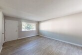 Located at 1890 Myrtle Dr SW in Atlanta, Georgia, this two-bedroom, one-bathroom single-story home offers a practical and straightforward layout. The living areas feature light-toned wood-look flooring and neutral gray walls, creating a clean and bright atmosphere throughout. Windows with blinds allow natural light to flow into the main living spaces, which connect seamlessly to the kitchen. The kitchen is well-equipped with gray upper cabinetry extending to the ceiling for ample storage, a stainless steel dishwasher and gas range, a black refrigerator, a double-basin sink, and light countertops. A rear door in the kitchen provides additional access. Both bedrooms are carpeted and offer a comfortable, quiet retreat, each with windows that bring in natural light. The primary bedroom includes closet access and connects to the hallway. The bathroom features a full tub and shower combo with classic white tile surround. Additional highlights include a dedicated utility room, two closets, and a second living area, offering flexible use of space. The home's consistent neutral palette and updated finishes provide a move-in ready setting in a residential Atlanta neighborhood.