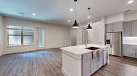 Located at 10400 Research Blvd in Austin, TX, this 1-bedroom, 2-bathroom residence offers a well-designed single-level layout with modern finishes throughout. The open-concept kitchen and living area serves as the heart of the home, featuring gray shaker-style cabinetry extending to the ceiling, a white quartz waterfall island, a classic tile backsplash, and a full suite of stainless steel appliances. Pendant lighting over the island and wood-look plank flooring add warmth and style to the space. The living room is generously proportioned, filled with natural light from large windows and a glass door that opens to a private patio overlooking a lush green courtyard framed by brick exteriors and a covered pergola. The bedroom is carpeted for comfort, includes a ceiling fan, and receives natural light through a sizable window. The primary bathroom impresses with a spacious walk-in shower clad in large-format travertine-style tile, a built-in bench, and a frameless glass enclosure. A dedicated laundry room houses a full-size side-by-side washer and dryer. Clean white walls, consistent trim work, and a neutral color palette create a cohesive and move-in-ready environment throughout.