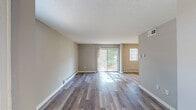 Located at 168 Estates Blvd in Trenton, NJ, this single-floor residence offers a well-organized layout designed for comfortable everyday living. The living area is a standout feature, showcasing wood-look plank flooring that runs throughout the main spaces, neutral gray-toned walls, and a textured ceiling. A sliding glass door floods the room with natural light and provides direct views of the surrounding greenery, while baseboard heating units line the perimeter. An adjacent area, partially visible from the living room, offers additional living or dining space with a window providing supplemental natural light.

The kitchen includes a window fitted with blinds, wood-look flooring, and space for standard appliances, including a full-size refrigerator. The layout connects efficiently to the rest of the unit via the central hallway.

Each bedroom features plush carpeting, neutral gray walls, a textured ceiling, and windows with blinds for natural light and privacy. Both bedrooms include closets with sliding or hinged doors and built-in rods for organized storage. The bathroom is appointed with large-format tile surrounding a full soaking tub and shower combination, complemented by brushed nickel fixtures for a clean, cohesive finish throughout.