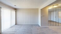 Located at 2615 Topeka in Wichita, KS, this 2-bedroom, 1-bathroom unit offers a practical and well-organized single-floor layout. The combined kitchen and living area forms the heart of the unit, with the kitchen featuring warm honey-oak cabinetry, tile countertops, a full-size refrigerator, an electric range, and a dishwasher. A double-basin sink is positioned beneath a window, allowing natural light into the space. Durable tile flooring runs throughout the kitchen area, while the living room offers plush carpeting and access to a sliding glass door framed by vertical blinds.

A connecting hallway leads to the two bedrooms, both finished with soft carpeting and neutral-toned walls beneath textured ceilings. The primary bedroom includes a built-in closet with a rod and shelf for ample storage. The second bedroom is comparably sized and well-lit by a window. The full bathroom is efficiently designed, featuring a wood-toned vanity with a white countertop, a large mirror, and tile flooring that mirrors the kitchen. Throughout the unit, the consistent use of neutral tones and practical finishes creates a clean, functional living environment.